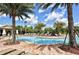 Resort style community pool surrounded by many sun loungers and palm trees at 6001 Anise Dr, Sarasota, FL 34238