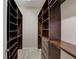 Large walk-in closet with custom dark wood shelving and drawers at 6001 Anise Dr, Sarasota, FL 34238