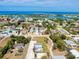 An aerial perspective reveals a vibrant community by the waterfront, speckled with lush trees and well-maintained homes under a blue sky at 612 Shore Rd, Nokomis, FL 34275