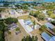 An aerial photograph displays a home surrounded by mature trees with tropical foliage in a quiet community and access to the waterfront at 612 Shore Rd, Nokomis, FL 34275