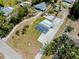 An aerial view of a house with a driveway, grass yard, and mature landscaping, and a glimpse of a neighborhood swimming pool at 612 Shore Rd, Nokomis, FL 34275