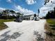 Exterior shot showcasing a lovely home, white gravel driveway, a car, and an RV on a sunny day at 612 Shore Rd, Nokomis, FL 34275