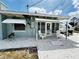 Inviting front porch with white chairs, a glass door, and stylish awnings, perfect for relaxing outdoors at 612 Shore Rd, Nokomis, FL 34275