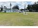 View of a charming home, with an RV and a car in the driveway, complemented by a well-kept lawn and the US flag at 612 Shore Rd, Nokomis, FL 34275