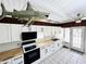 Recently renovated kitchen, equipped with new white cabinets, butcher block countertops and stainless appliances; tiled floors at 612 Shore Rd, Nokomis, FL 34275