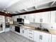 Bright kitchen featuring white cabinetry, butcher block countertops, and modern black appliances at 612 Shore Rd, Nokomis, FL 34275