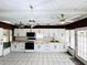 Bright kitchen features white cabinets, butcher block countertops, ceiling fan, and unique shark decor; bathed in natural light at 612 Shore Rd, Nokomis, FL 34275