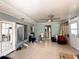 Spacious sunroom with tile flooring, fan, and natural light from doors and windows, perfect for relaxation at 612 Shore Rd, Nokomis, FL 34275