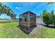 View of backyard featuring a screened gazebo, grassy lawn, and secure white privacy fence at 7420 Tuttle Ave, Sarasota, FL 34243