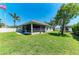 Expansive backyard showcasing a screened-in patio, lush lawn, and privacy fence for outdoor enjoyment at 7420 Tuttle Ave, Sarasota, FL 34243