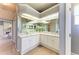 Well lit bathroom with a double sink, granite countertops, large mirror and white cabinets at 7420 Tuttle Ave, Sarasota, FL 34243