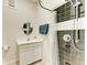 Bathroom features a shower with glass door, and white vanity with a round mirror at 7420 Tuttle Ave, Sarasota, FL 34243