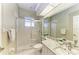 Modern bathroom with granite countertops, a glass shower, and sleek white cabinets at 7420 Tuttle Ave, Sarasota, FL 34243