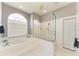 Bright bathroom featuring a soaking tub, a separate glass-enclosed shower and tiled floors at 7420 Tuttle Ave, Sarasota, FL 34243