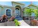 Elegant front entrance with stone accents, decorative plants, and a stylish glass door at 7420 Tuttle Ave, Sarasota, FL 34243