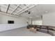 Finished garage space with carpet, entertainment center and a sectional sofa creates a comfortable living area at 7420 Tuttle Ave, Sarasota, FL 34243