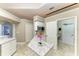 Modern kitchen with granite countertops, an island, and a microwave, conveniently adjacent to a hallway and bathroom at 7420 Tuttle Ave, Sarasota, FL 34243