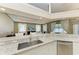Bright kitchen with granite countertops, a stainless sink, and an open layout to the living area, enhancing the flow at 7420 Tuttle Ave, Sarasota, FL 34243