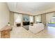 Bright living room featuring tile flooring, a large ceiling fan, and sliding glass doors leading to the patio at 7420 Tuttle Ave, Sarasota, FL 34243