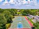 Outdoor basketball court with vibrant markings, set within a verdant, tree-lined neighborhood with a parking area at 7582 Camden Harbour Dr, Bradenton, FL 34212