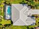 Overhead shot of a home featuring a screened pool, spa, meticulously maintained lawn and an elegant driveway at 7582 Camden Harbour Dr, Bradenton, FL 34212