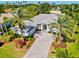 Aerial view of a beautifully landscaped home with a circular driveway and surrounded by lush greenery at 7582 Camden Harbour Dr, Bradenton, FL 34212