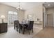 Formal dining room with a large window, elegant chandelier, and access to the hallway at 7582 Camden Harbour Dr, Bradenton, FL 34212