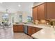 Bright kitchen features warm wood cabinetry, tile backsplash, and stainless steel appliances, adjacent to dining area at 7582 Camden Harbour Dr, Bradenton, FL 34212