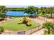 Community playground featuring modern equipment set against the backdrop of a serene lake view at 7582 Camden Harbour Dr, Bradenton, FL 34212