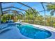 Sparkling pool with screened enclosure and poolside seating area surrounded by lush landscaping at 7582 Camden Harbour Dr, Bradenton, FL 34212