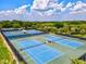 Aerial view of the community's many well maintained tennis courts, surrounded by lush landscaping and trees at 7582 Camden Harbour Dr, Bradenton, FL 34212