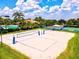 Community volleyball court next to pool, tennis courts and lush landscaping on a clear day at 7582 Camden Harbour Dr, Bradenton, FL 34212