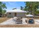 Home features a brick patio with seating and a fire pit in backyard at 815 Hand Ave, Sarasota, FL 34232