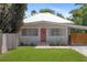A cute home with a metal roof, a well-maintained yard and a long concrete driveway at 815 Hand Ave, Sarasota, FL 34232