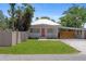 A charming single-story home with a metal roof, long concrete driveway, and lush lawn at 815 Hand Ave, Sarasota, FL 34232