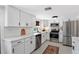 Modern kitchen with stainless steel appliances, white cabinets, stylish backsplash, and sleek countertops at 815 Hand Ave, Sarasota, FL 34232