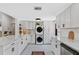 A modern kitchen featuring white cabinetry, marble countertops, stackable washer/dryer, and decorative rug at 815 Hand Ave, Sarasota, FL 34232