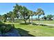 Lush backyard view featuring mature trees, manicured lawns, and a glimpse of the pond and golf course at 9470 High Gate Dr # 2213, Sarasota, FL 34238