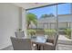 Covered patio with a glass table, four wicker chairs, and an outdoor view at 9470 High Gate Dr # 2213, Sarasota, FL 34238