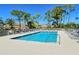 Relaxing community swimming pool with plenty of lounge chairs, trees, and landscaping at 9470 High Gate Dr # 2213, Sarasota, FL 34238