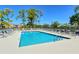 Inviting community swimming pool surrounded by lounge chairs, umbrellas, and manicured grounds at 9470 High Gate Dr # 2213, Sarasota, FL 34238