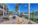 Relaxing backyard oasis with fire pit, poolside lounge chairs, and picturesque waterfront at 975 Whitakers Ln, Sarasota, FL 34236