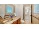 Bathroom with granite counters, vanity and tiled floors with a shower room view in the background at 975 Whitakers Ln, Sarasota, FL 34236