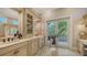 Elegant bathroom boasts dual sinks, custom cabinetry, and outdoor access to a spacious balcony at 975 Whitakers Ln, Sarasota, FL 34236