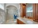 Bathroom featuring tiled floors, glass shower with marble accents, and cherry wood vanity at 975 Whitakers Ln, Sarasota, FL 34236
