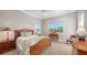 Cozy bedroom featuring natural wood furnishings, two windows, and a comfortable seating area at 975 Whitakers Ln, Sarasota, FL 34236