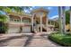 Elegant estate showcasing its grand exterior with a curved staircase and lush landscape at 975 Whitakers Ln, Sarasota, FL 34236