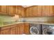 Functional laundry room with modern washer and dryer, granite countertops, and ample cabinet space at 975 Whitakers Ln, Sarasota, FL 34236