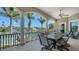 Covered patio featuring a dining table and stunning waterfront views with palm trees at 975 Whitakers Ln, Sarasota, FL 34236