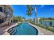 Beautiful pool with waterfront views, steps, and tropical landscaping at 975 Whitakers Ln, Sarasota, FL 34236